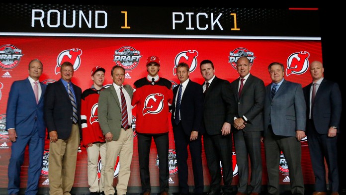 Nico Hischier (uprostred) pózuje v drese hokejového tímu New Jersey Devils, ktorý si ho vybral ako jednotku draftu 2017.