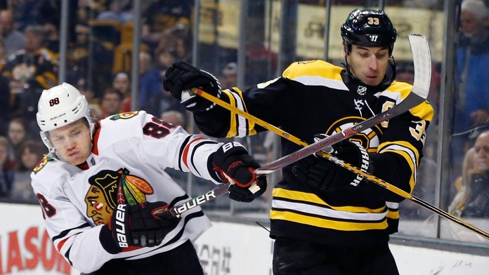 Patrick Kane (Chicago) a Zdeno Chára (Boston) v súboji o puk.