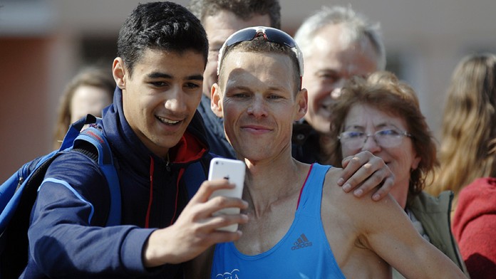 Chodec Matej Tóth s fanúšikmi po príchode do cieľa preteku na 50 km na Dudinskej päťdesiatkej.