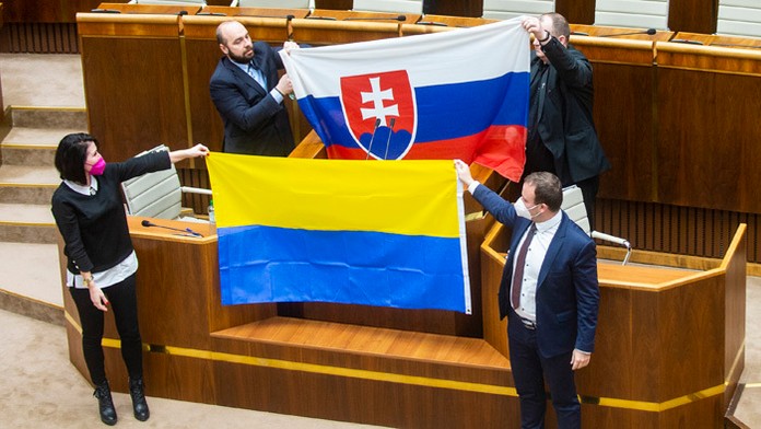 Zľava Andrej Medvecký, Peter Krupa (obidvaja ĽSNS) držia slovenskú vlajku a dole Jana Bittó Cigániková a Miroslav Žiak (obidvaja