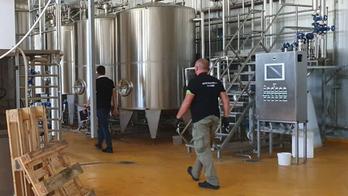 Na snímke policajti v jednej z mliekarní na Slovensku pri razii Technológ.