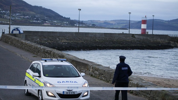 Írsky policajt hliadkuje v Buncrana Pier, kde spadlo do mora auto s piatimi ľuďmi. 