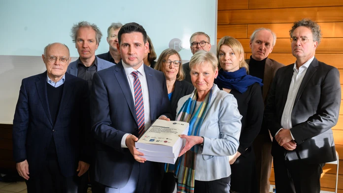Martin Wazlawik, koordinátor výskumnej siete "ForuM", odovzdáva na tlačovej konferencii úradujúcej predsedníčke Rady Evanjelickej cirkvi v Nemecku (EKD) Kirsten Fehrsovej štúdiu o zneužívaní v protestantskej cirkvi.