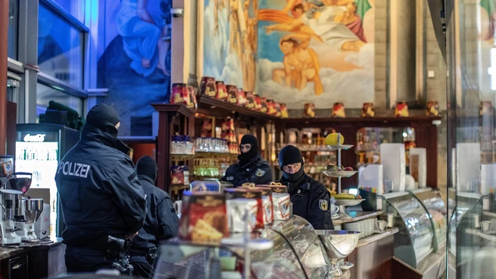 Nemeckí policajti počas razie proti členom 'Ndranghety v kaviarni Duisburgu.