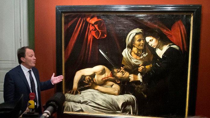 Aukčný úradník Marc Labarbe prezentuje nájdený obraz, ktorého autorom by mohol byť Caravaggio.