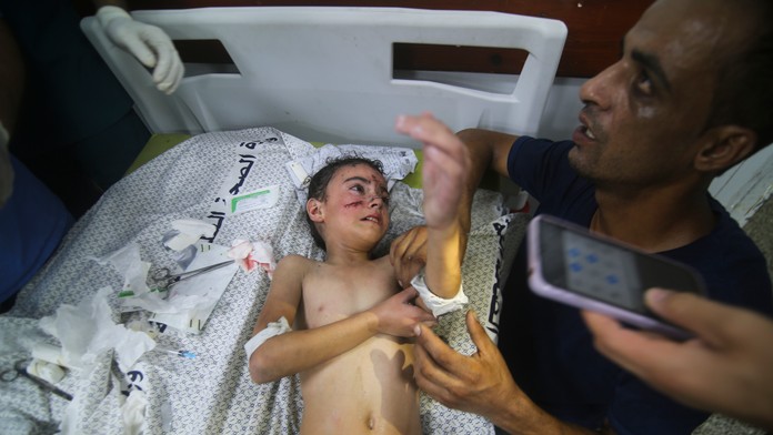 Palestínčania sedia pred ich zničeným domom po izraelskom leteckom útoku v utečeneckom tábore Rafah na juhu pásma Gazy