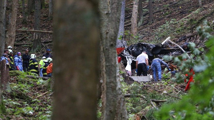 Záchranári, hasiči a vyšetrovatelia pri troskách zrúteného záchranárskeho vrtuľníka v horách 5 kilometrov od obce Strelníky.