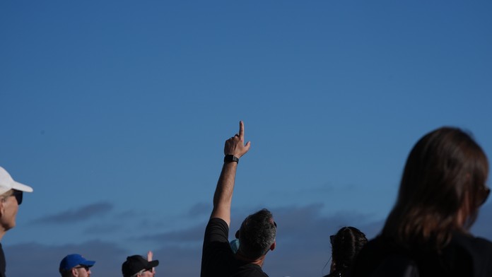 Na snímke ľudia čakajú na návrat posádky misie Artemis II na pláži v Coronade v Kalifornii.