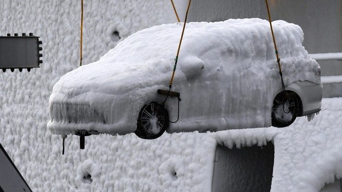 Z nákladnej lode vykladajú auto obalené ľadom.