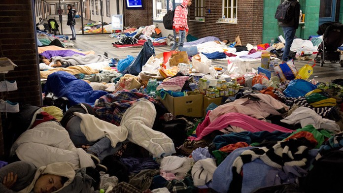 Migranti nocujú na železničnej stanici v severonemeckom Flensburgu.