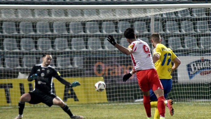 Na snímke uprostred hráč ŠKF Sereď Roko Jureškin strieľa gól brankárovi MFK Zemplín Michalovce Andrijovi Kožucharovi.