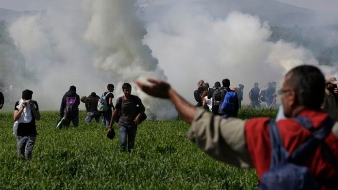 Na snímke macedónska polícia zakročila proti skupine asi 500 migrantov, ktorí sa v Grécku pokúsili preraziť hraničné oplotenie v