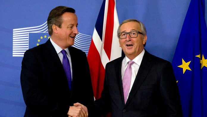 Britský premiér David Cameron si podáva ruku a predseda Európskej komisie Jean-Claude Juncker