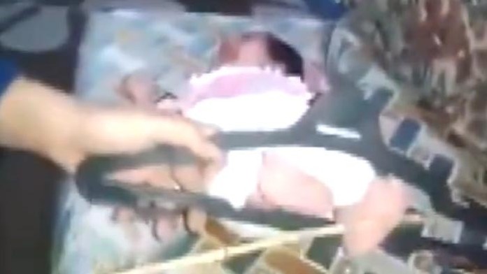 Otec "vychováva" svoju malinkú dcérku. Bije ju po nožičkách.