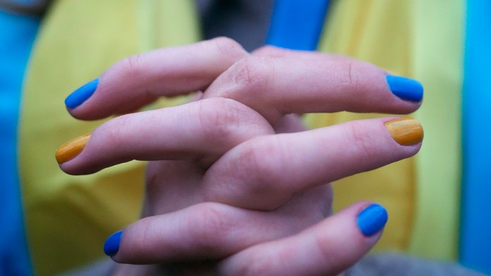 Žena s nechtami namaľovanými v národných farbách Ukrajiny.