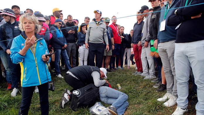 Muž ratuje ženu po tom, čo ju nechtiac loptičkou trafil do hlavy golfista Brooks Koepka počas Ryder Cupu.