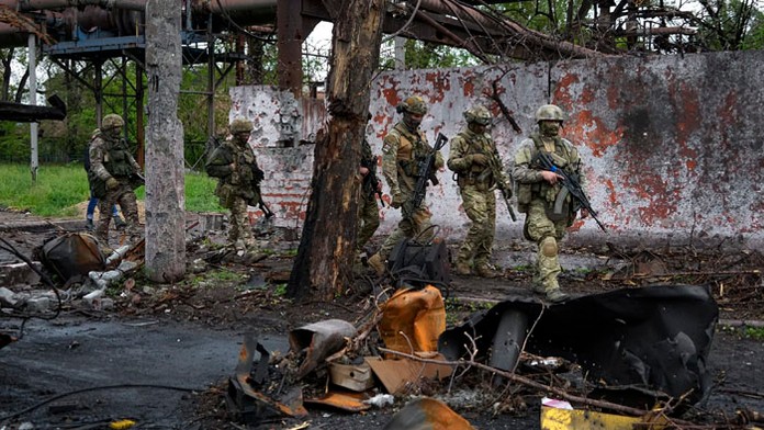 Ruské jednotky kráčajú v zničenej časti hutníckeho závodu v Mariupole.