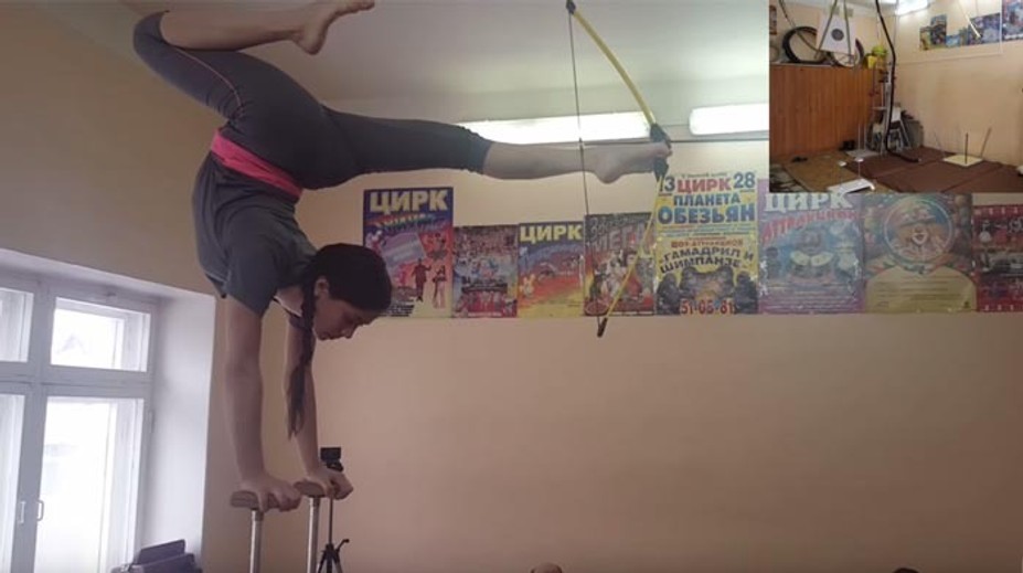 Len 12-ročná Ruska má nevídaný talent. Stojí na rukách a nohami strieľa z luku