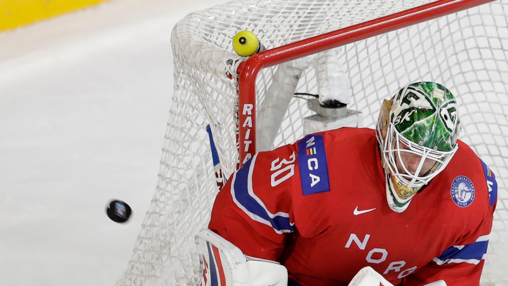 Bielorus Jevgenij Lisovec (vľavo) strieľa na brankára Nórov Larsa Haugena.