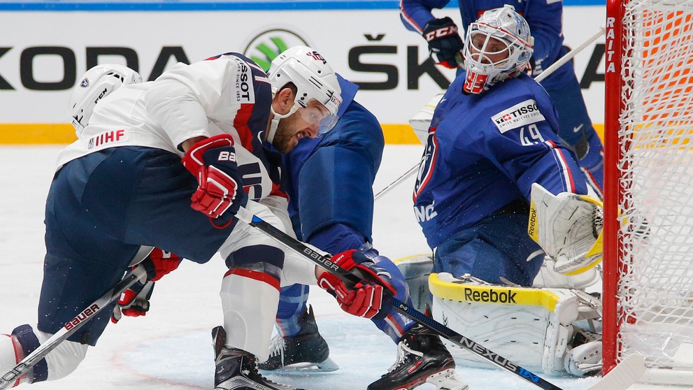 Hráč USA Nick Foligno (vľavo) v súboji o puk pred brankárom Francúzska Florianom Hardym.
