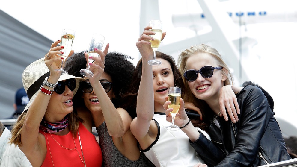 Diváčky so šampanským zdravia pretekárov počas Veľkej ceny Monaka na okruhu v Monte Carle.