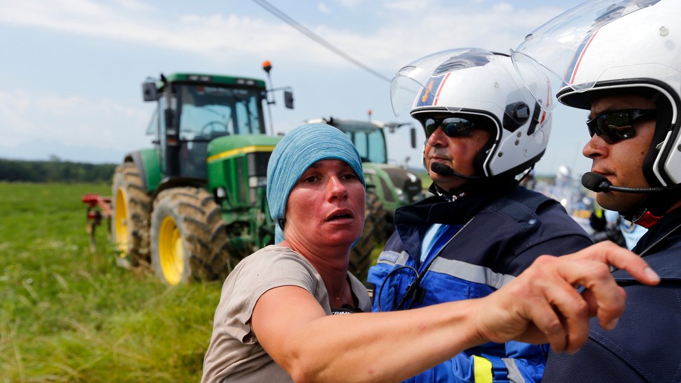 Polícia zatýka ženu počas protestov farmárov na 16. etape Tour de France.