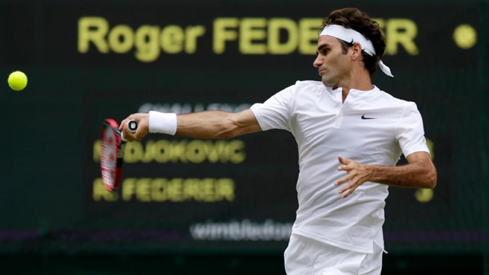 Roger Federer vo finále Wimbledonu odvracia loptičku Novaka Djokoviča.