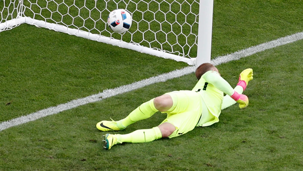 Anglický brankár Joe Hart inkasuje gól po priamom kope Walesana Garetha Balea.
