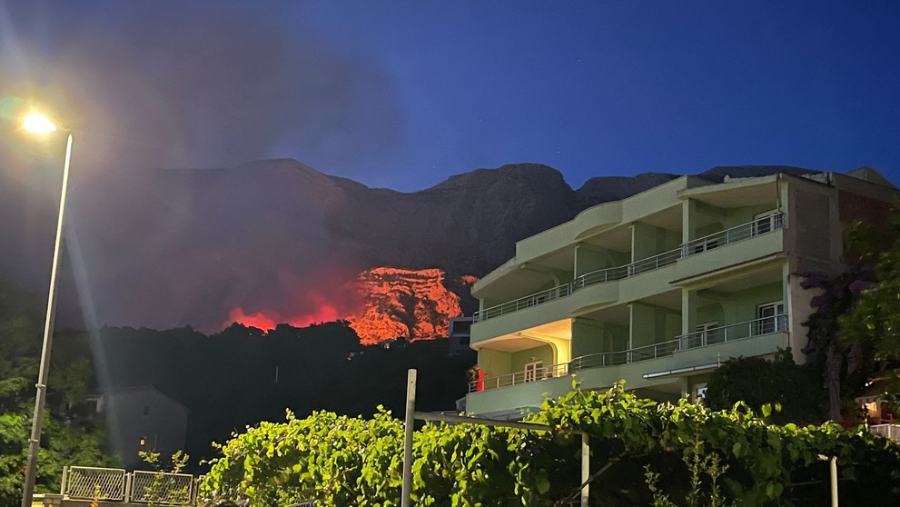 Hasiči sa snažia uhasiť požiar, ktorý v utorok večer vypukol pri mesteTučepi ležiacom neďaleko Makarskej