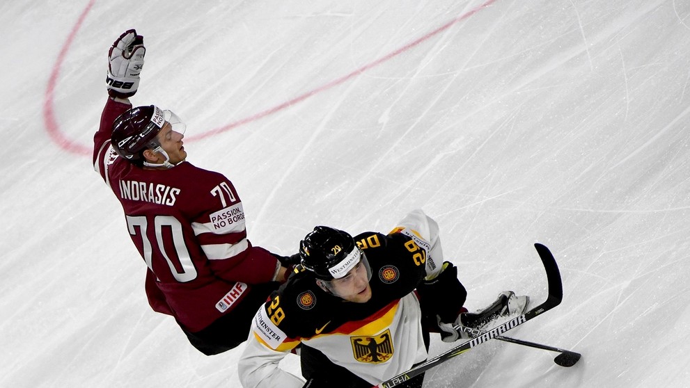 Lotyš Miks Indrašis (vľavo) atakuje nemeckého útočníka Leona Draisaitla v zápase MS 2017.