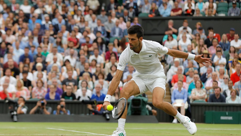Novak Djokovič odvracia úder Adriana Mannarina v osemfinále Wimbledonu.