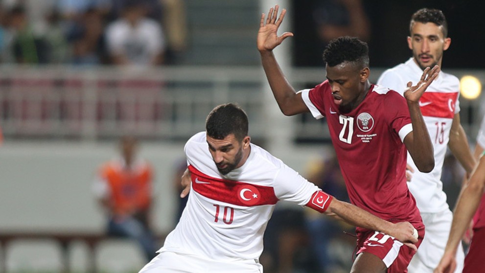 Katarský hráč Mohammed Muntari (vpravo) a turecký hráč Arda Turan v prípravnom zápase.