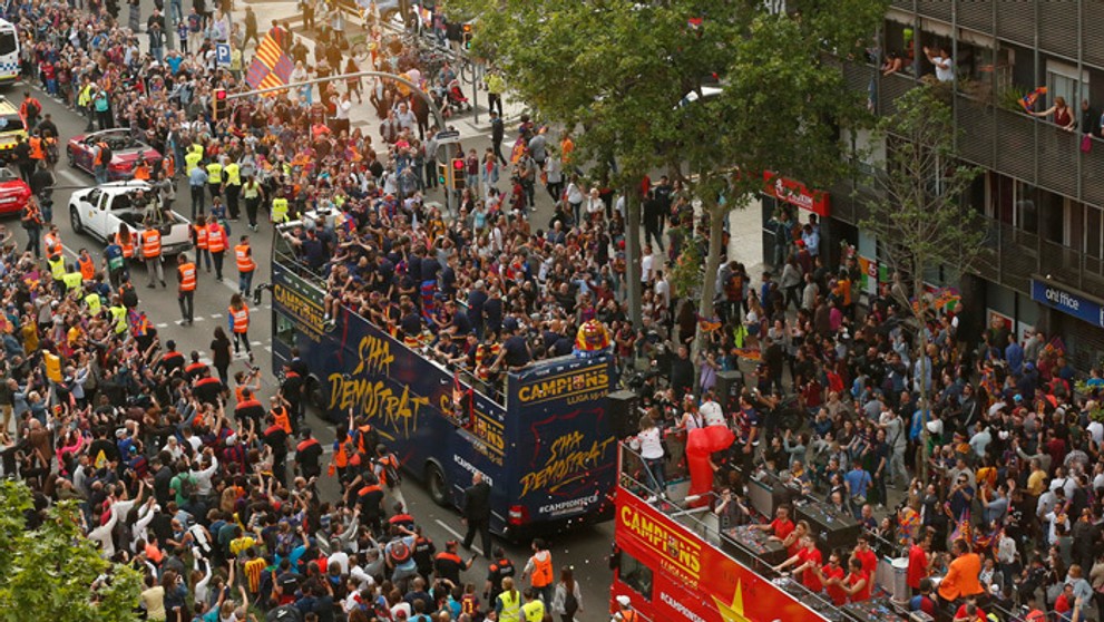 Hráči FC Barcelona oslavujú v otvorenom autobuse ligový titul v uliciach mesta.