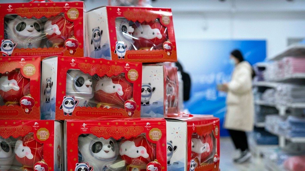 Návštevníci si prezerajú predmety v obchode so suvenírmi v olympijskej dedine.