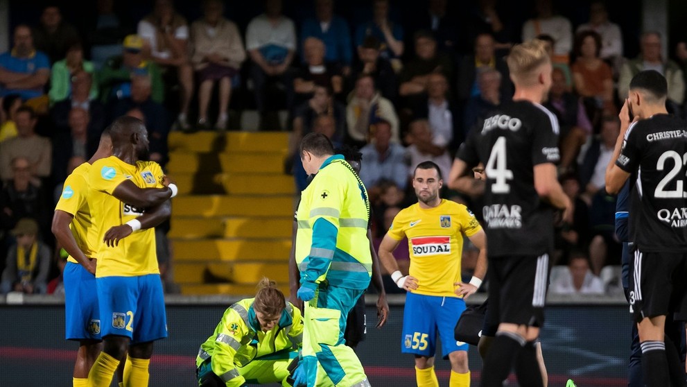 Ján Bernát leží zranený na trávniku.