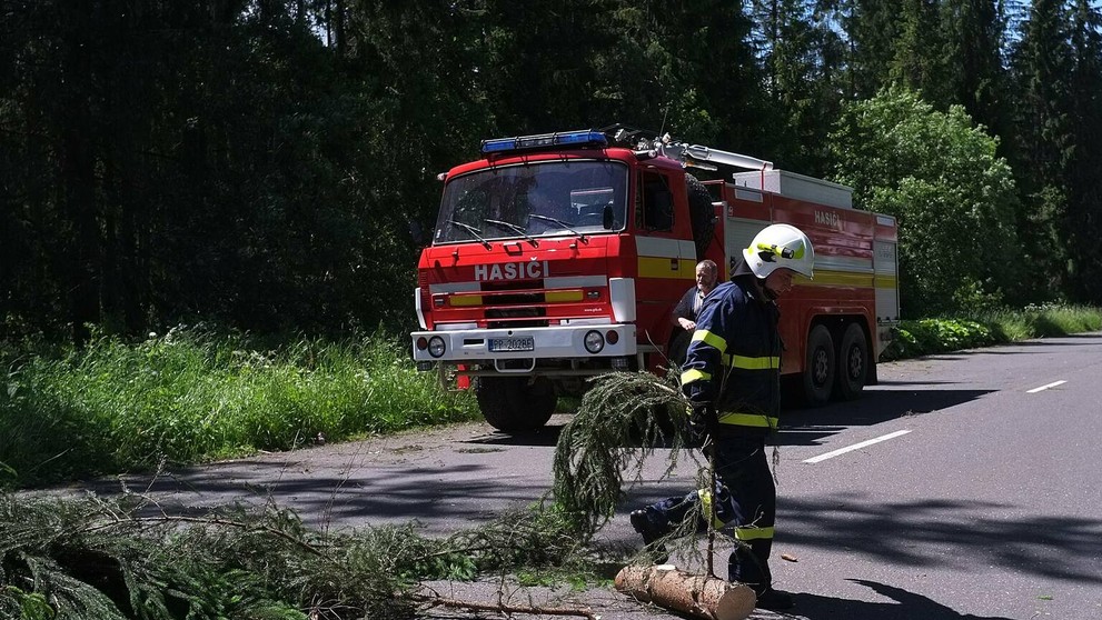 Na snímke hasiči a dobrovoľní hasiči zo Ždiaru odpratávajú popadané stromy z cesty