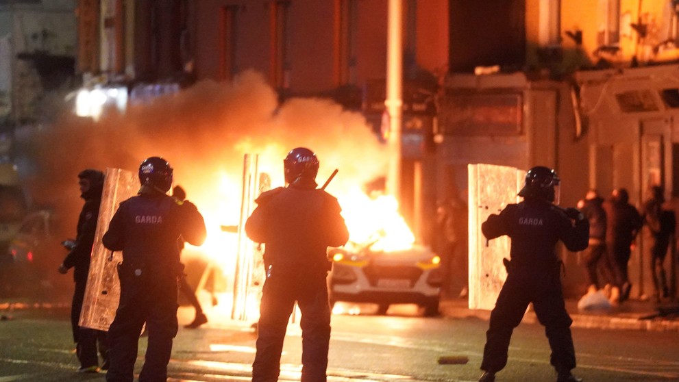 Na snímke auto horí počas demonštrácie na mieste útoku v centre Dublinu