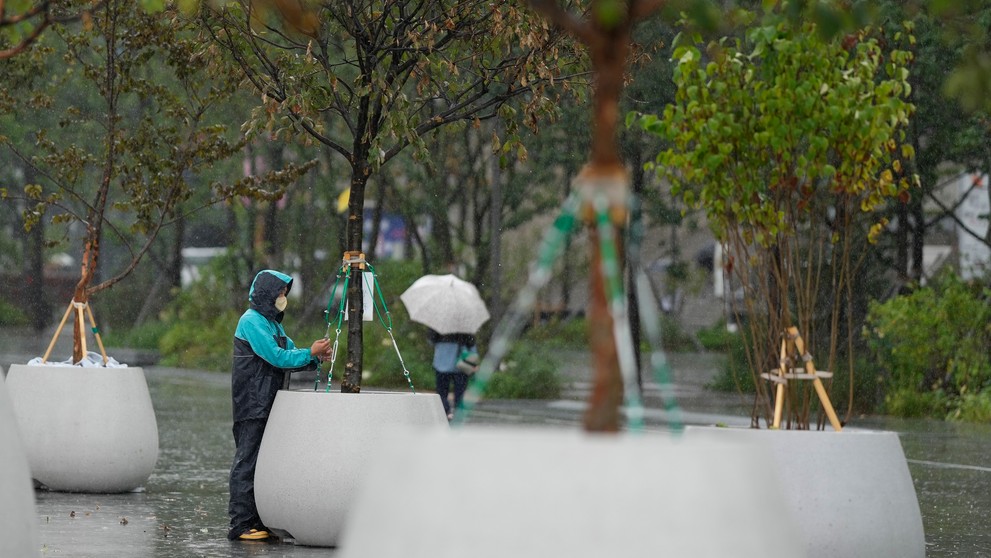 Pracovník kontroluje technické zariadenie na námestí pred príchodom tajfúnu Hinnamnor