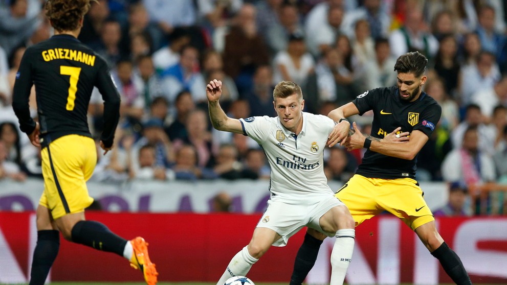 Toni Kroos z Realu bojuje o loptu s Yannickom Carrascom z Atlética v semifinále LM.