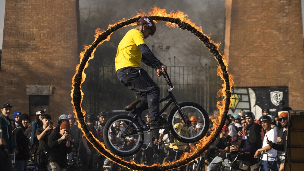 Cyklista predvádza trik počas skoku cez horiacu obruč na podujatí BMX Day v čilskom Santiagu.