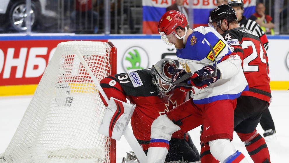 Ivan Telegin (v strede) z Ruska atakuje kanadského brankára Calvina Pickarda (vľavo) v semifinále MS 2017.