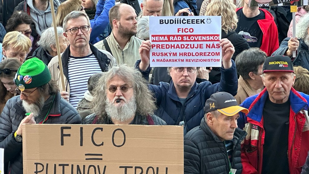 Protestujúci s protivládnymi transparentami