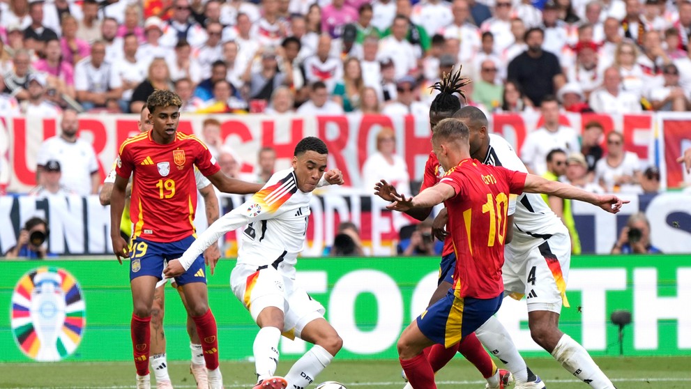 Jamal Musiala v súboji s Danim Olmom.