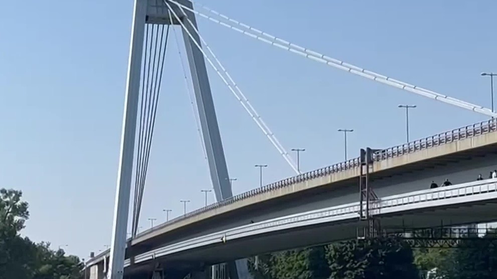 Muž sedí na zábradlí Mosta SNP