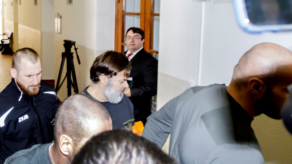 Dušan Dědeček prichádza v sprievode členov Zboru väzenskej a justičnej stráže prichádza do súdnej siene na Okresnom súde Bratislava I v stredu 25. januára 2023.