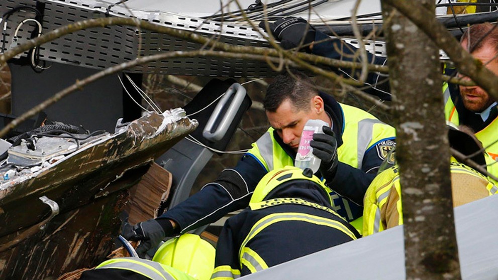 záchranári sa venujú zranenému pasažierovi na mieste zrážky dvoch vlakov v nemeckom Bad Aiblingu.