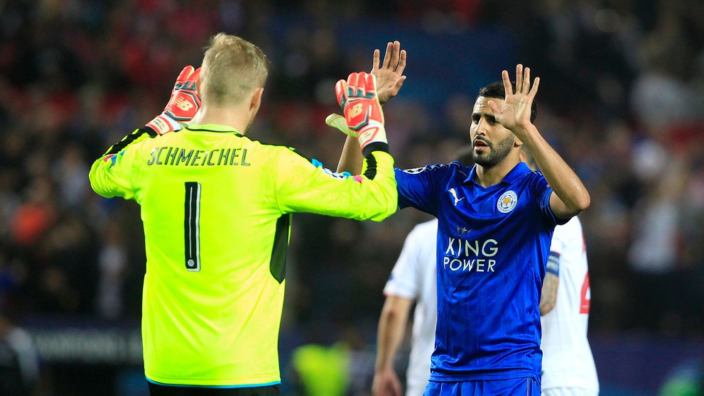 Brankár Leicestru Kasper Schmeichel si podáva ruku so spoluhráčom Riyadom Mahrezom v osemfinále LM proti Seville.