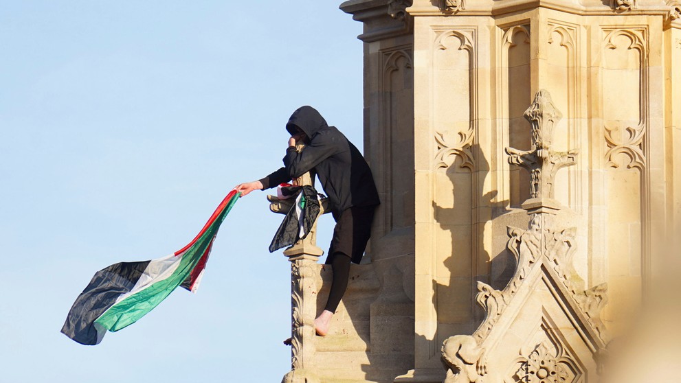 Muž máva s palestínskou vlajkou na Big Bene
