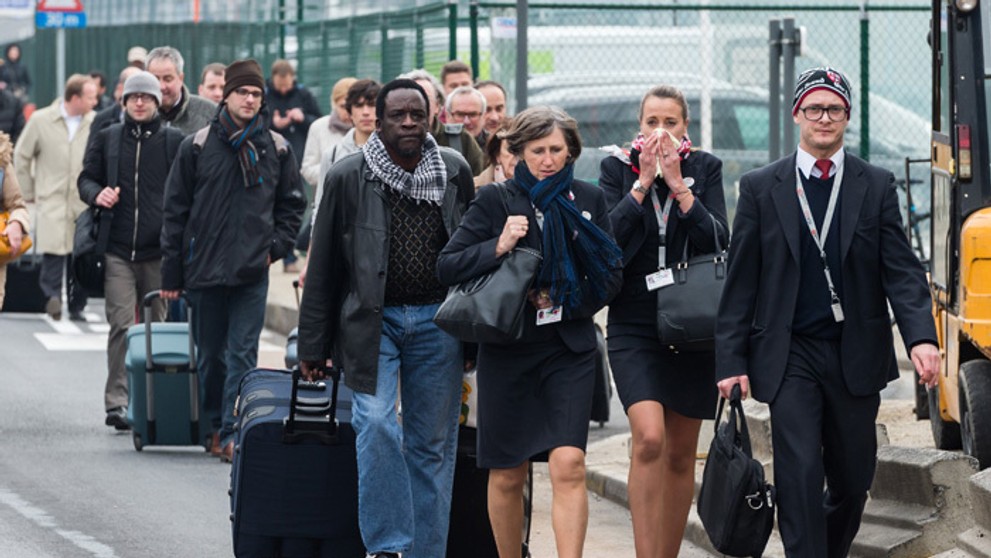 Cestujúci a letecký personál opúšťajú bruselné letisko Zaventem po teroristických výbuchoch.