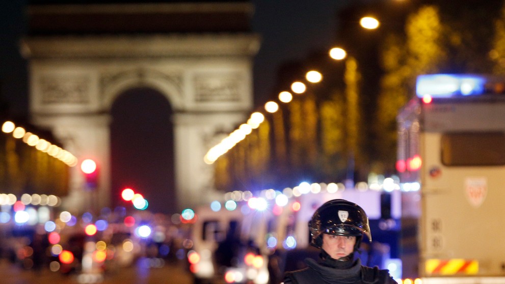 Na snímke policajt hliadkuje na bulvári Champs-Élysées v centre Paríža, kde došlo k streľbe.